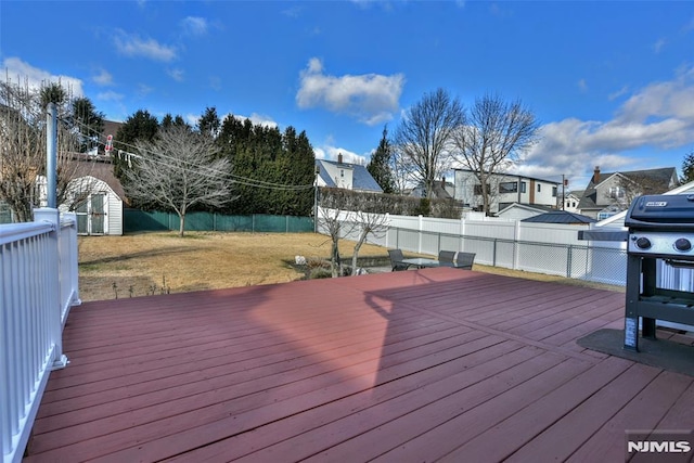 wooden deck featuring a storage unit and a yard