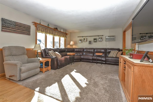 living room featuring a wall mounted air conditioner and hardwood / wood-style flooring