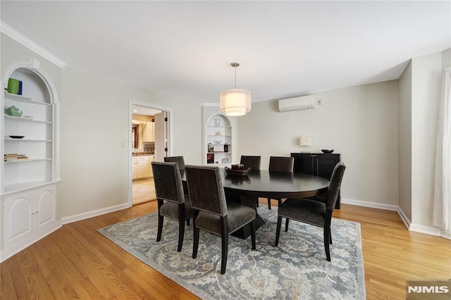 dining space with light wood-type flooring, built in shelves, and a wall mounted air conditioner