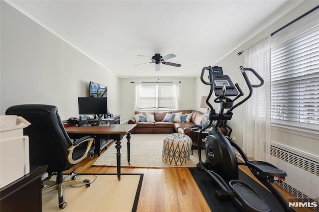 office space with wood-type flooring, radiator heating unit, and ceiling fan