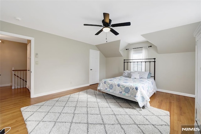 bedroom with ceiling fan, lofted ceiling, and hardwood / wood-style flooring