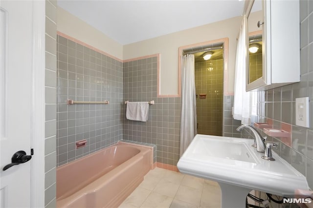 bathroom featuring sink, shower / tub combo with curtain, tile patterned floors, and tile walls