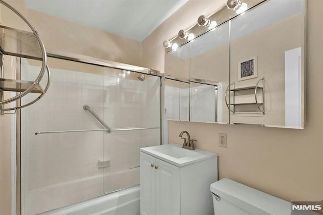 full bathroom featuring combined bath / shower with glass door, vanity, and toilet