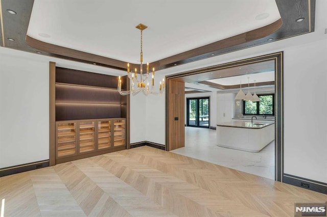 dining space with a raised ceiling and an inviting chandelier