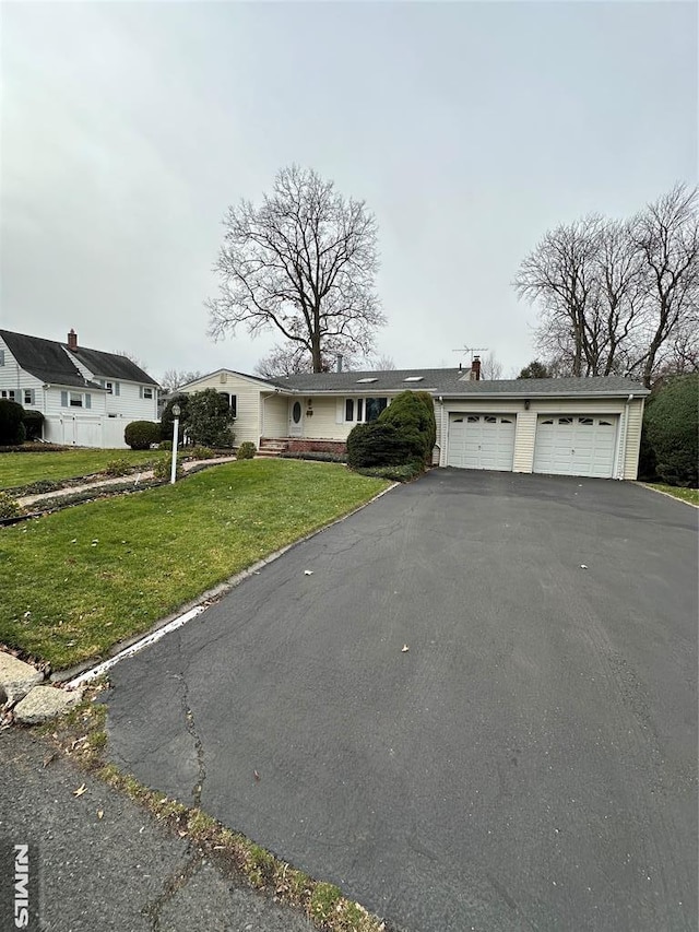 single story home with a garage and a front lawn