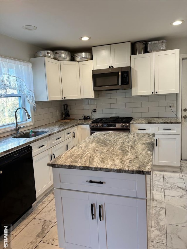 kitchen with light stone countertops, backsplash, stainless steel appliances, and white cabinetry