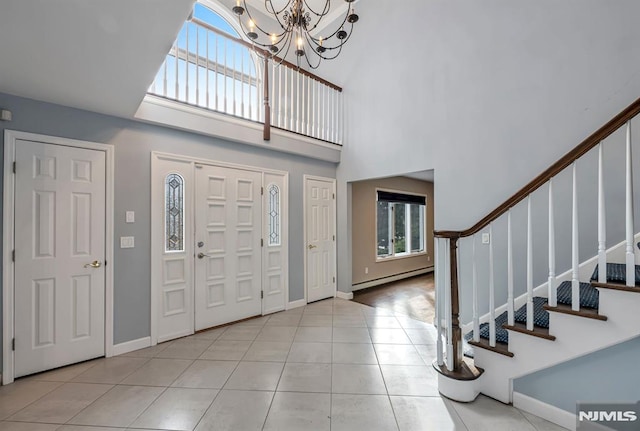 tiled foyer entrance featuring an inviting chandelier, a high ceiling, and a baseboard heating unit