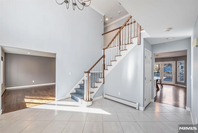 staircase featuring tile patterned floors, french doors, a baseboard radiator, and a notable chandelier