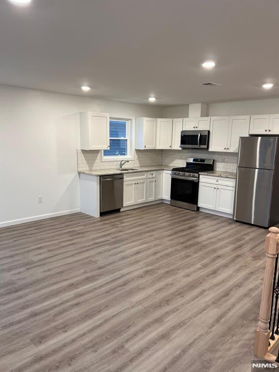 kitchen with appliances with stainless steel finishes, white cabinetry, and sink