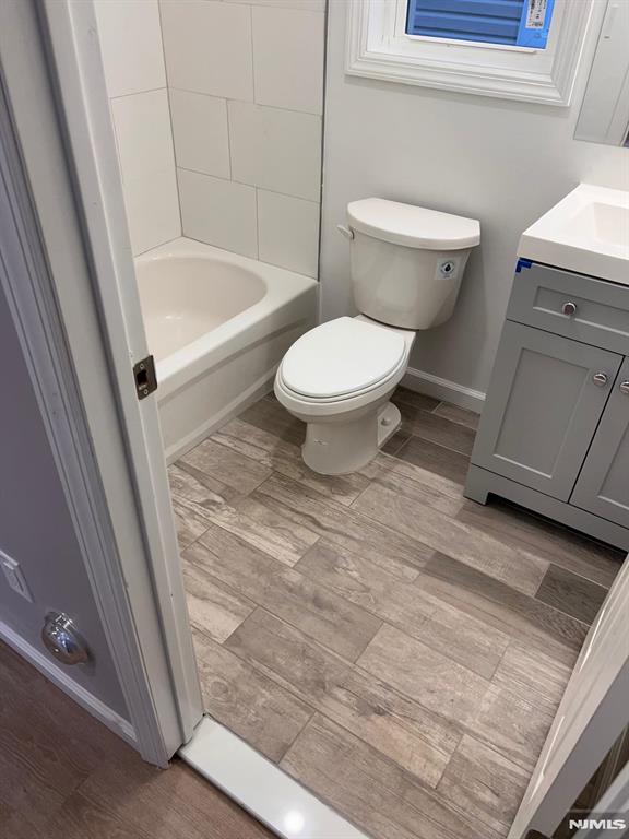 full bathroom featuring bathing tub / shower combination, vanity, and toilet