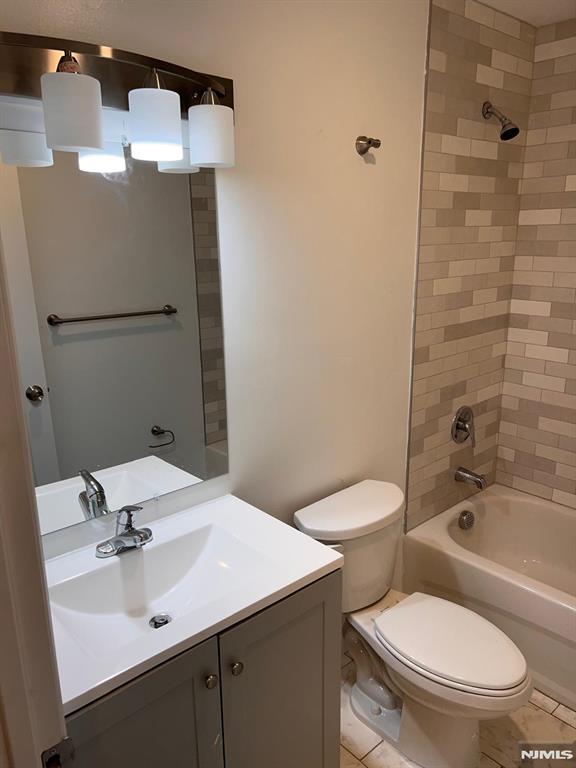 full bathroom with tile patterned floors, vanity, toilet, and tiled shower / bath