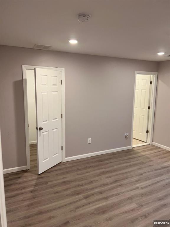 unfurnished room with dark hardwood / wood-style flooring