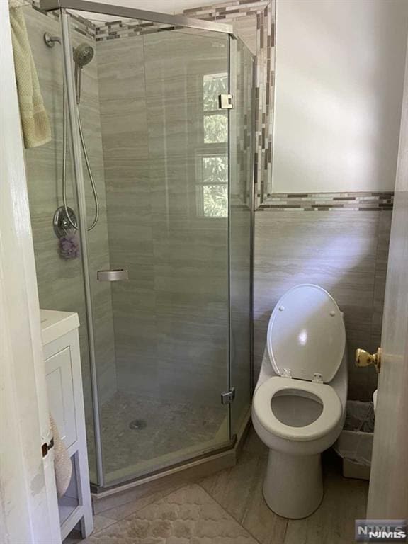 bathroom with tile patterned floors, toilet, and walk in shower