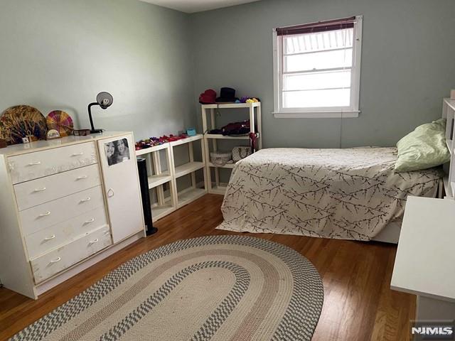 bedroom with dark hardwood / wood-style flooring