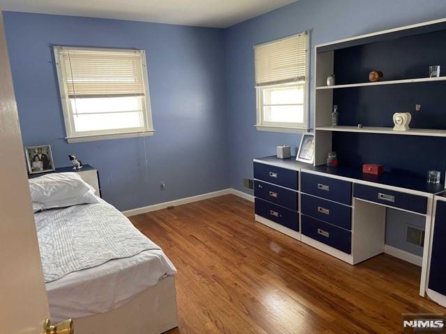 bedroom featuring multiple windows and dark wood-type flooring