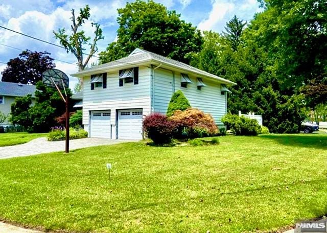 view of side of home with a garage and a yard