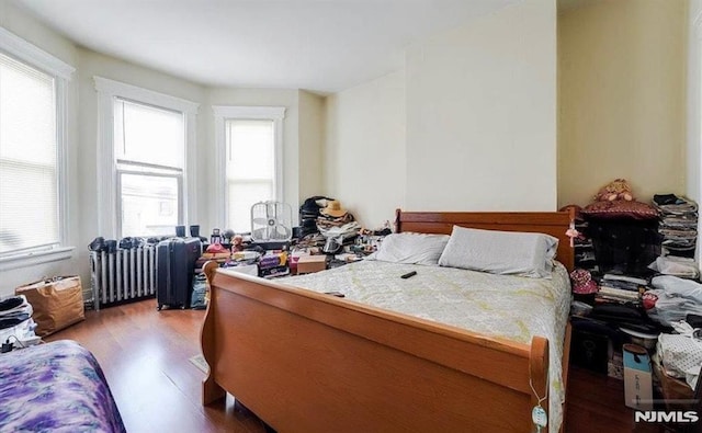 bedroom with radiator and wood-type flooring