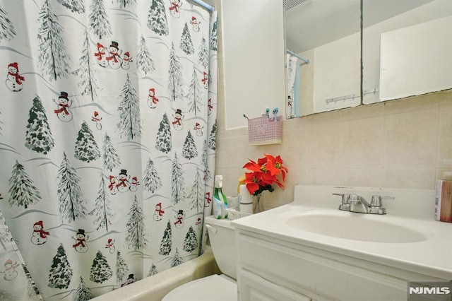 full bathroom featuring tile walls, toilet, shower / bath combo, backsplash, and vanity