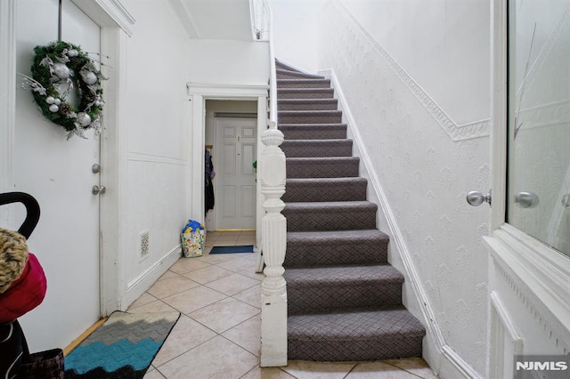 stairway with tile patterned floors