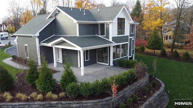 rear view of property with a lawn and a patio area