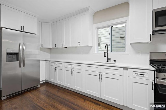 kitchen featuring dark hardwood / wood-style floors, white cabinetry, sink, and appliances with stainless steel finishes