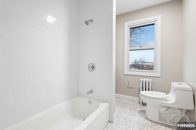 bathroom featuring tile patterned floors, tiled shower / bath, and toilet