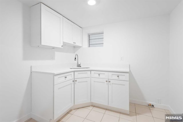 clothes washing area featuring light tile patterned floors and sink