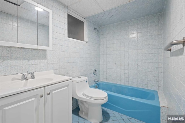 full bathroom featuring vanity, tile patterned flooring, toilet, tile walls, and tub / shower combination