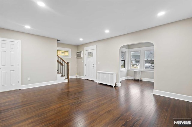 interior space with a healthy amount of sunlight, dark hardwood / wood-style flooring, and radiator heating unit