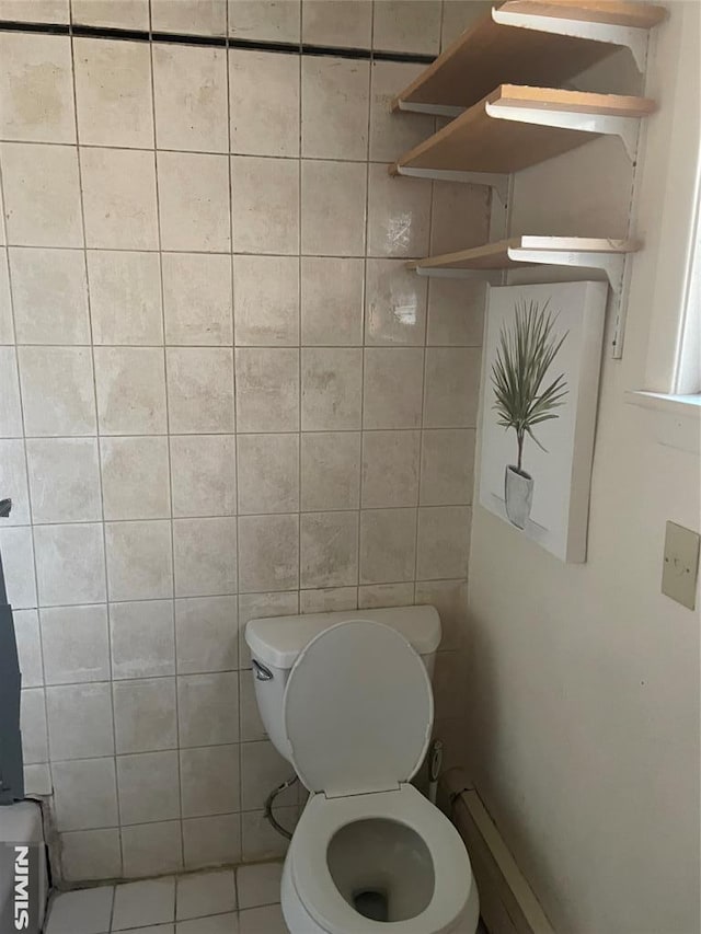 bathroom with tile patterned flooring, tile walls, and toilet