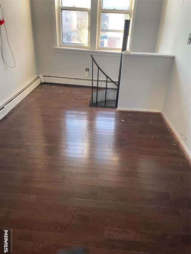 spare room featuring a wealth of natural light and dark wood-type flooring