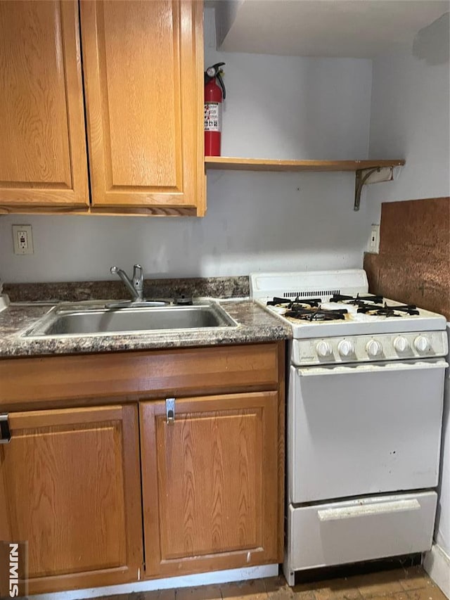 kitchen with white gas range and sink