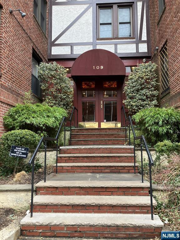 view of exterior entry featuring french doors and brick siding