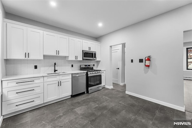 kitchen featuring stainless steel appliances, white cabinetry, baseboard heating, and sink