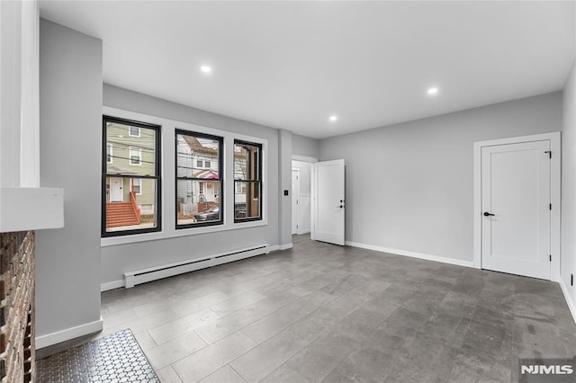 empty room featuring a stone fireplace and a baseboard heating unit