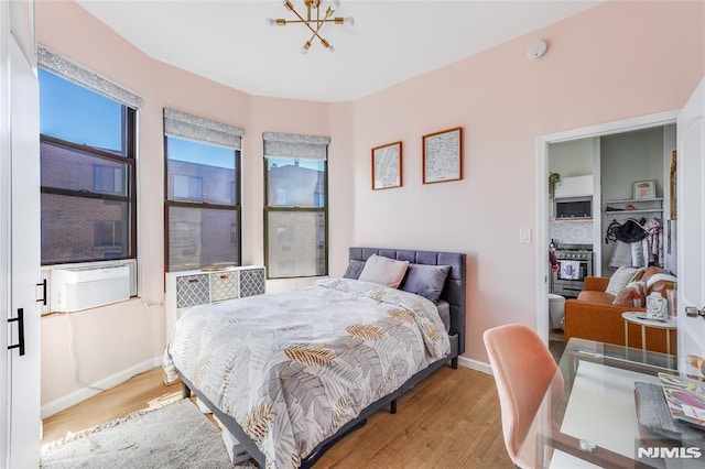 bedroom featuring a notable chandelier, light hardwood / wood-style flooring, and a closet