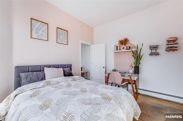 bedroom with a baseboard radiator and hardwood / wood-style floors