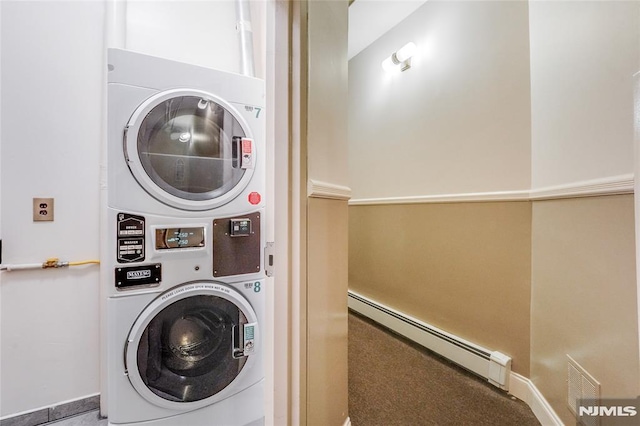 laundry room featuring baseboard heating and stacked washing maching and dryer