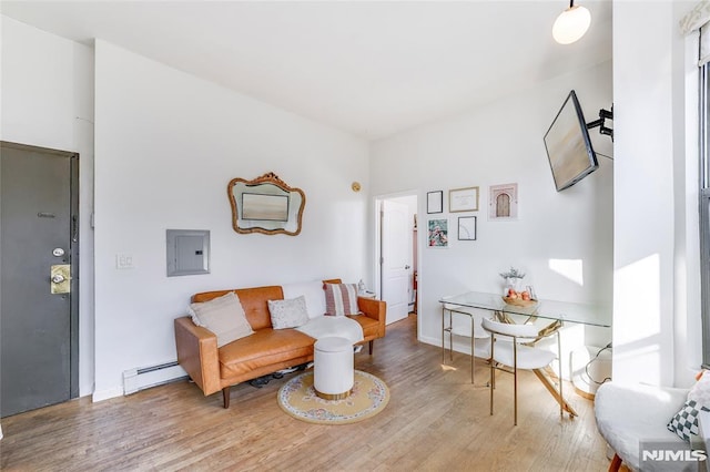 living area featuring electric panel, a baseboard heating unit, and hardwood / wood-style flooring