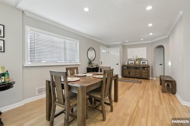 dining space with crown molding and light hardwood / wood-style floors