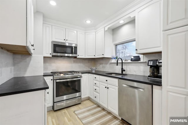 kitchen featuring sink, white cabinetry, light hardwood / wood-style flooring, and stainless steel appliances