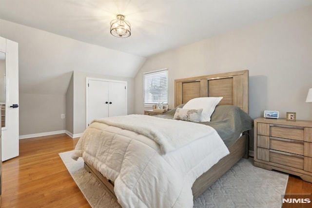 bedroom featuring light hardwood / wood-style flooring and lofted ceiling