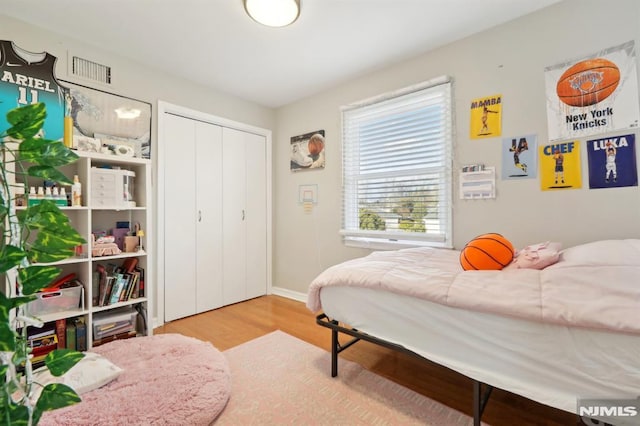 bedroom with a closet and hardwood / wood-style floors