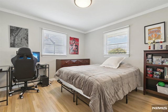 bedroom with crown molding and light hardwood / wood-style floors