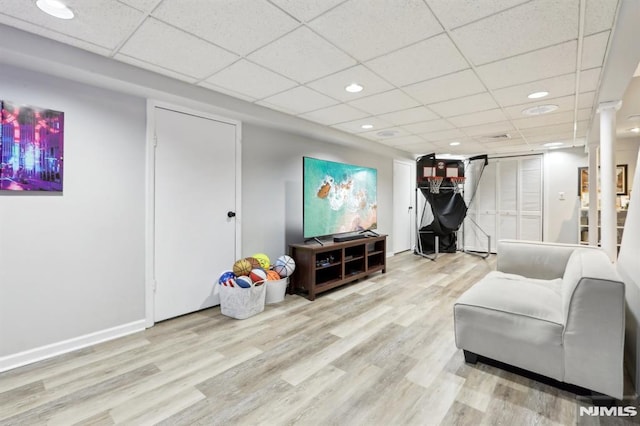 interior space featuring a drop ceiling and light hardwood / wood-style floors