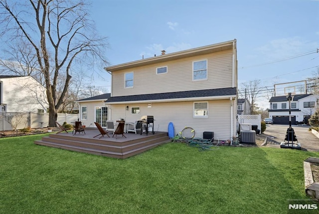 rear view of property with a wooden deck, a yard, and central air condition unit