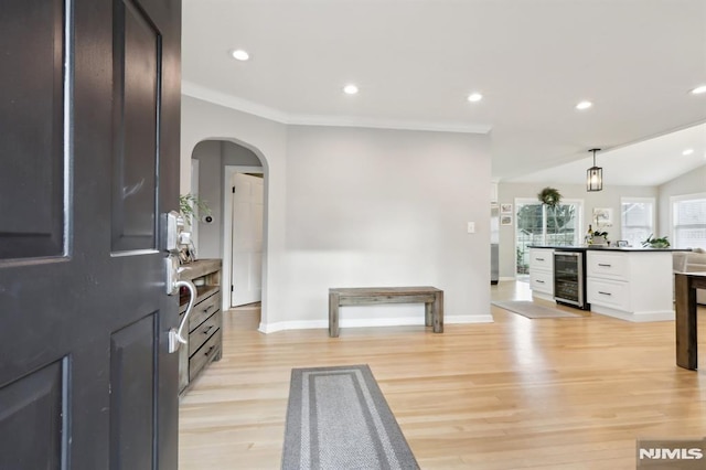 entryway featuring light hardwood / wood-style floors, ornamental molding, and wine cooler