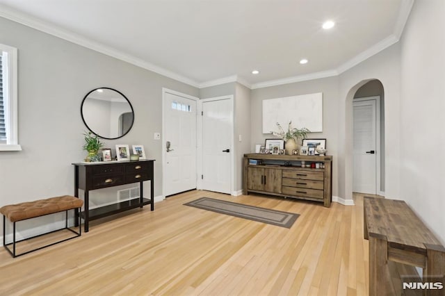 foyer entrance featuring ornamental molding and hardwood / wood-style floors