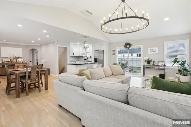 living room featuring light wood-type flooring and vaulted ceiling