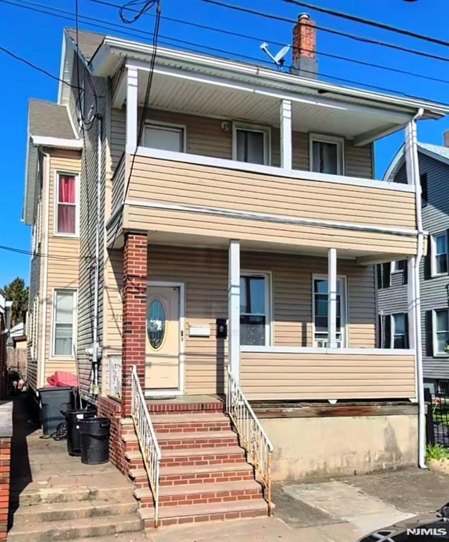 view of front of property featuring a balcony and a porch